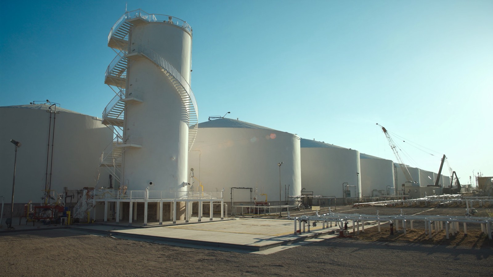 Oil and gas process site with storage tanks and pipework